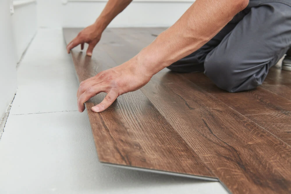 Worker joining vinyl floor covering.