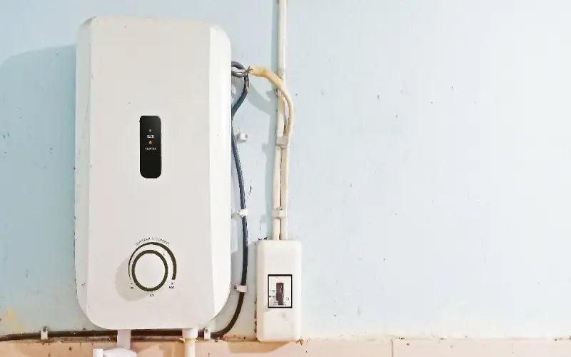 A tankless water heater attached to the wall of a bathroom in a Wichita, KS home.