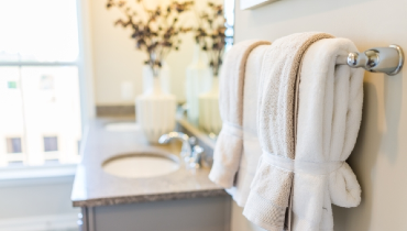 Modern bathroom with two sinks and towels hanging from towel rack.