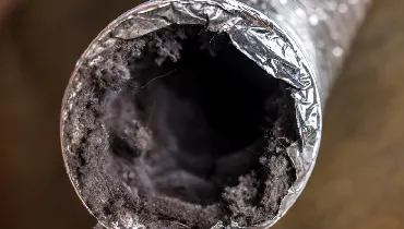 A dirty laundry flexible aluminum dryer vent duct ductwork filled with lint, dust and dirt.