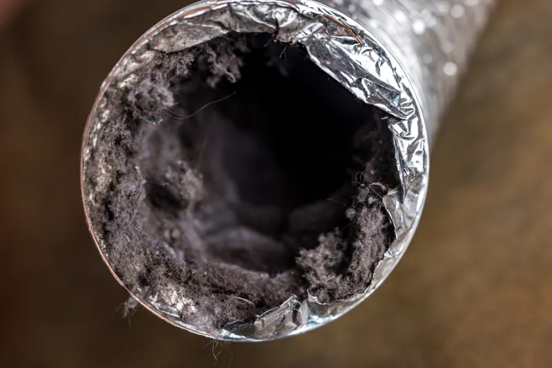 A dirty laundry flexible aluminum dryer vent duct ductwork filled with lint, dust and dirt.