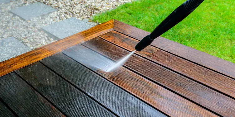 A grimey wood deck being cleaned and refinished with professional power washing service.