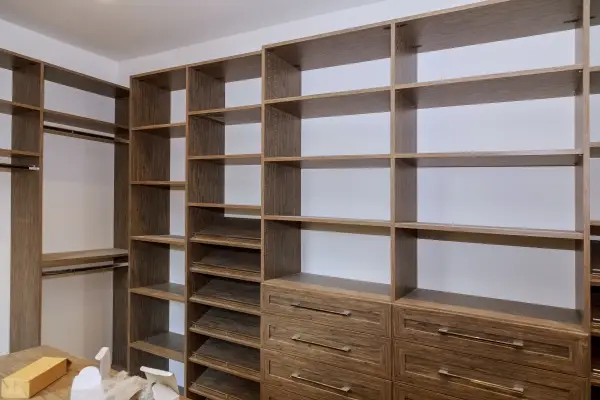 Large walk-in closet with many shelves and drawers