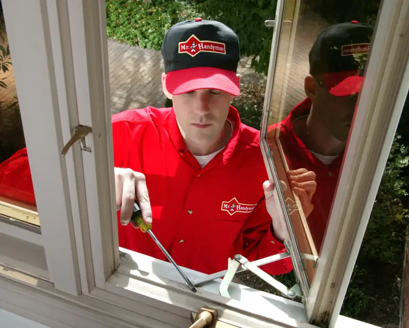 Mr. Handyman employee fixing window