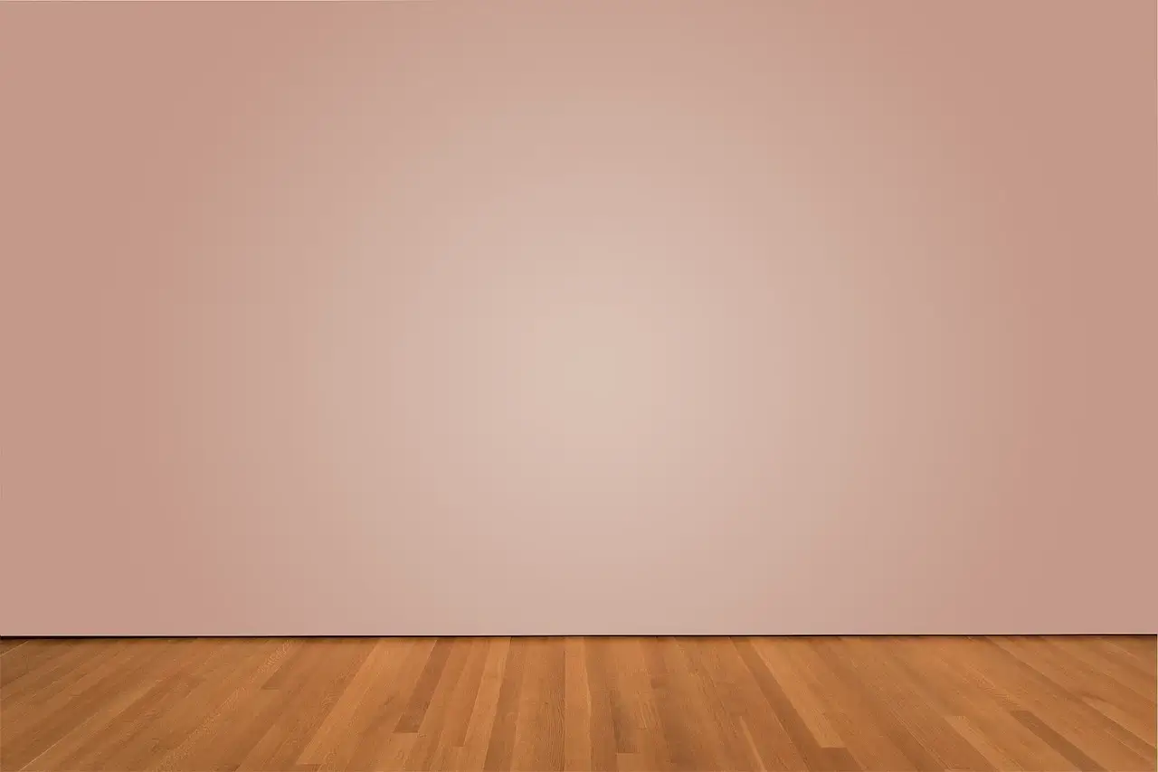 A smooth pink wall and a wooden floor.