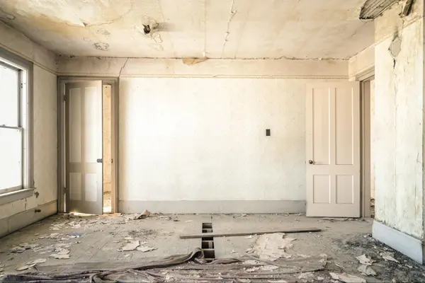 Residential room with construction debris on the floor.