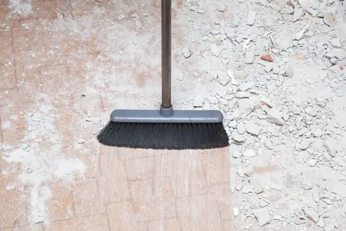 Broom sweeping dust and concrete during home renovation
