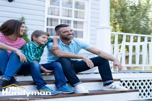 family sitting on front porch steps home