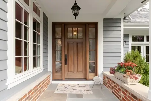 Front door entryway of a suburban home showing curb appeal with a freshly installed door