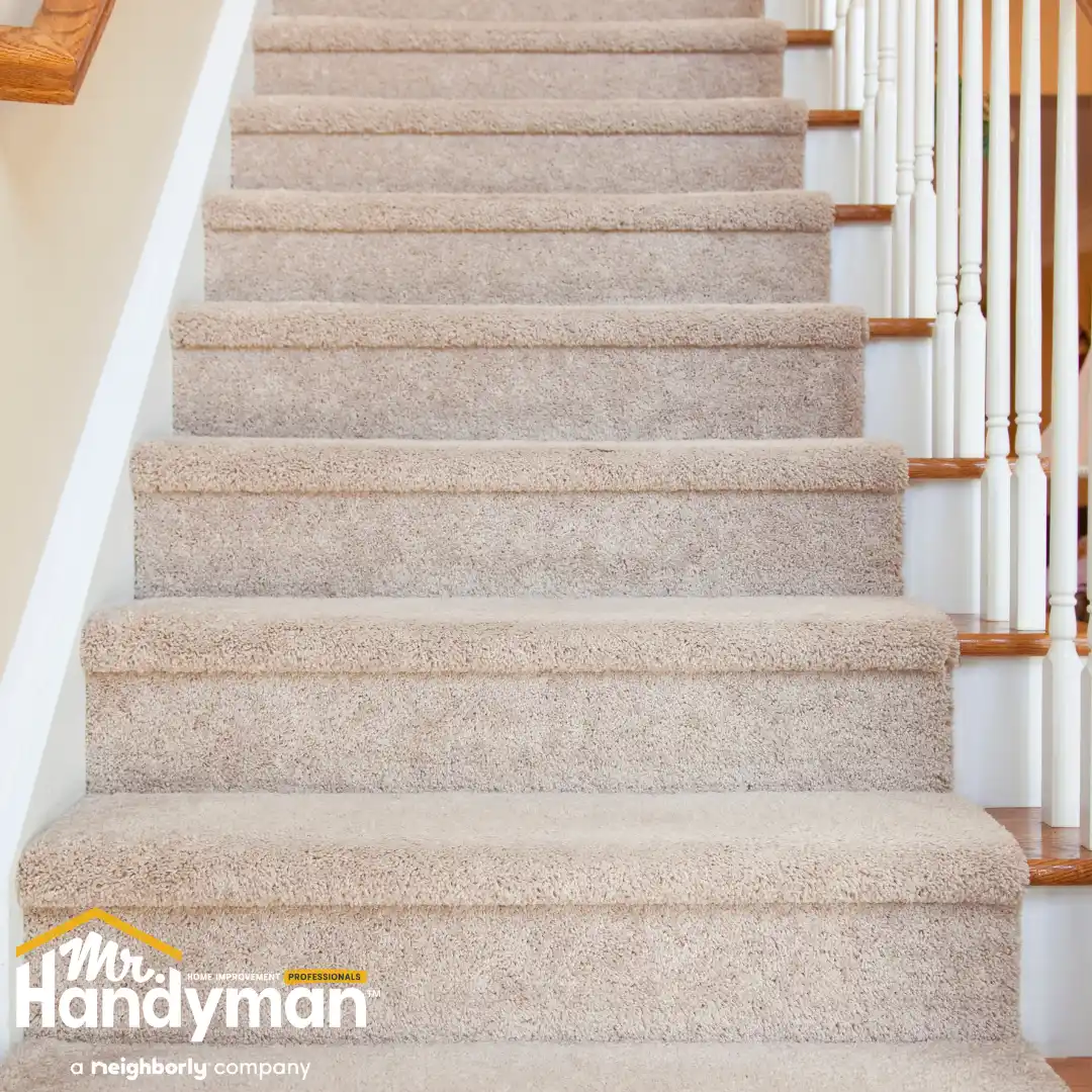 Carpeted staircase featuring soft, beige steps and wooden railing.