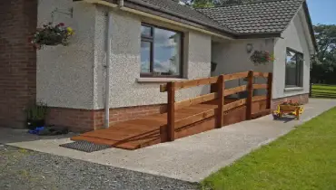 a wooden wheelchair ramp leading to residential entry.