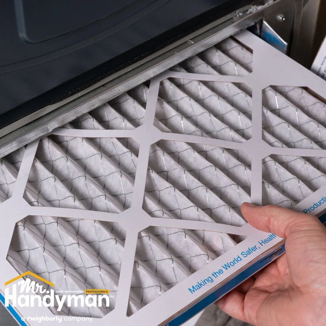 A hand holds an air filter with a hexagonal design.