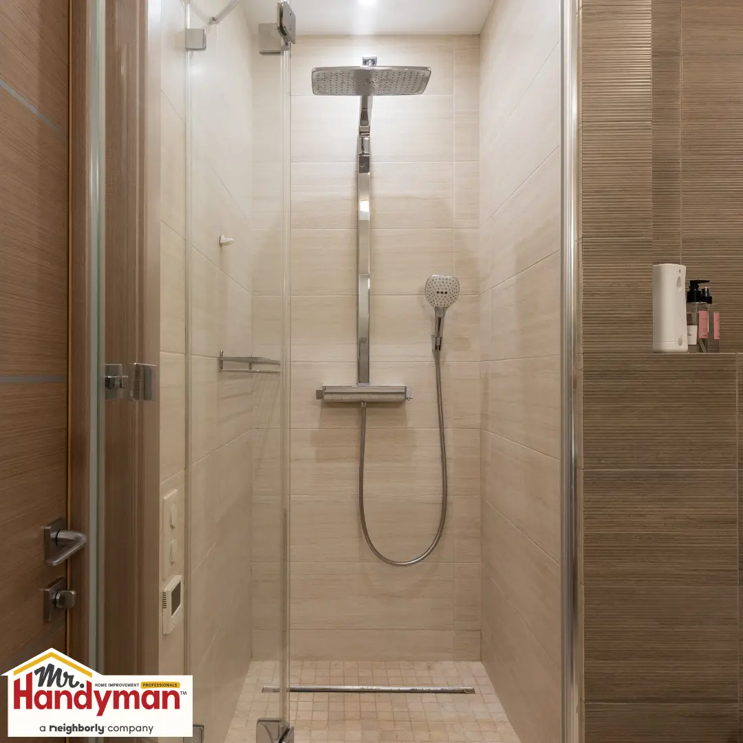 Handyman installing walk-in shower tile during a bathroom remodel in South Bend Indiana