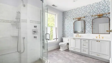 Modern bathroom remodel with updated gold fixtures and layout.