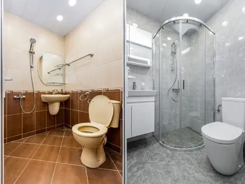 Bathroom renovation with cosmetic updates, including tile, vanity, toilet, shower enclosure, and lighting.