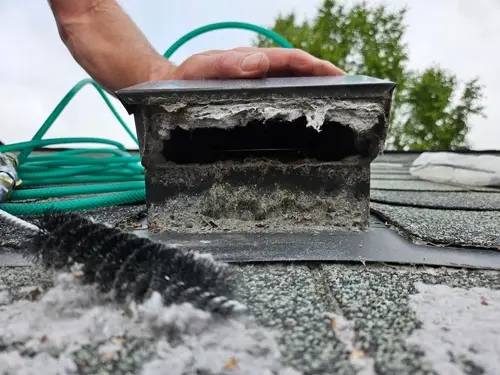 Man dryer vent accumulation on exhaust; in need of dryer vent service.