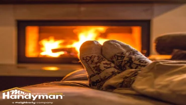 A person relaxes in front of a cozy fireplace.