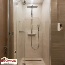 Handyman installing walk-in shower tile during a bathroom remodel in South Bend Indiana