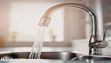 Mr. Handyman technician inspecting outdoor hose bib and plumbing connections on a home in Wichita Kansas