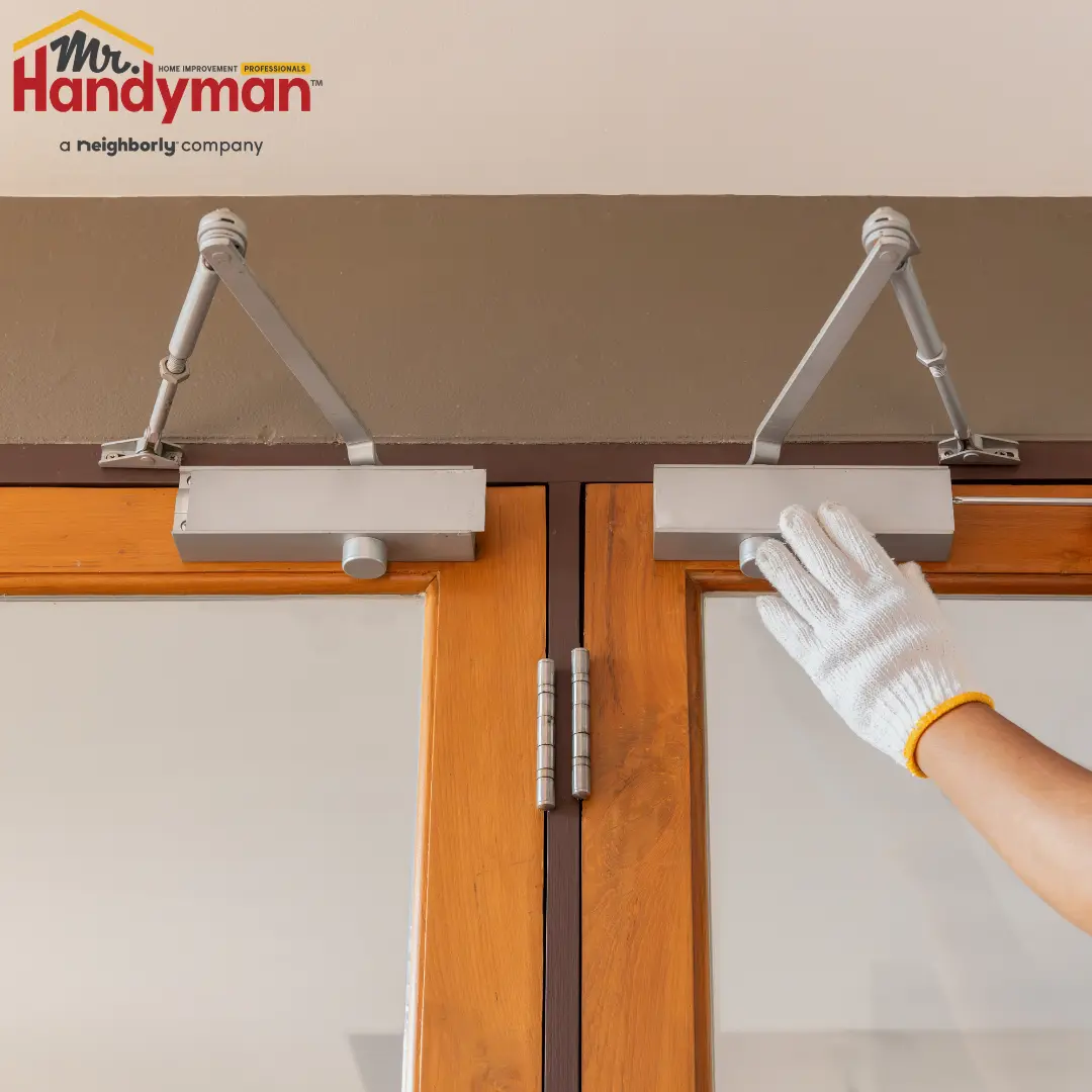 Mr. Handyman technician repairing entry flooring and door hardware in a high-traffic Franklin, Tennessee business
