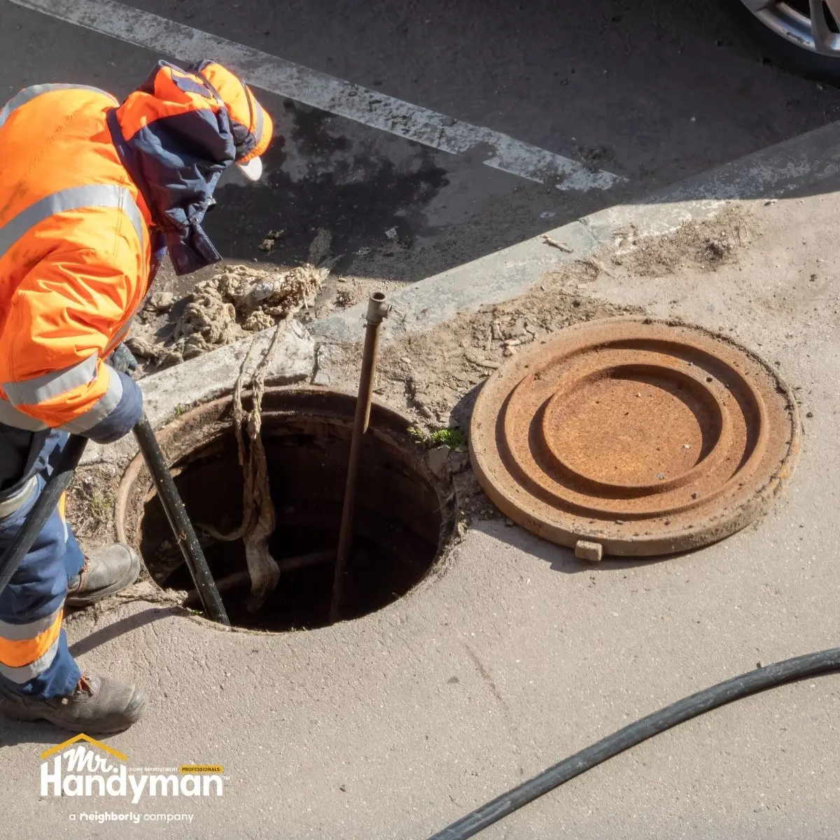 A worker examining a manhole.