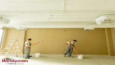 Handyman painting a commercial interior wall to refresh a business space in Cedar Hill Texas