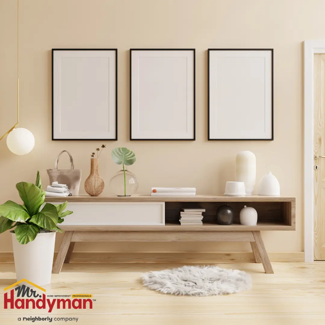 A clean and organized living room with a white wall and a wooden floor.