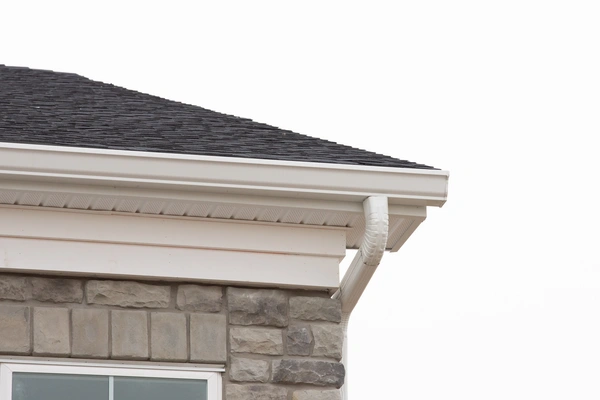 A close-up view of the corner of a house featuring a stone facade.