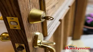 Close-up view of a wooden door with a keyhole, door handle, and lock.