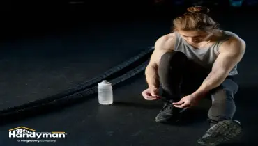 Mr. Handyman technician inspecting and repairing commercial gym flooring at a Nashville fitness facility
