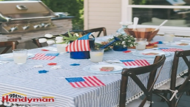  A backyard table set for a celebration, decorated with American flags, star-shaped ornaments, and fresh flowers.