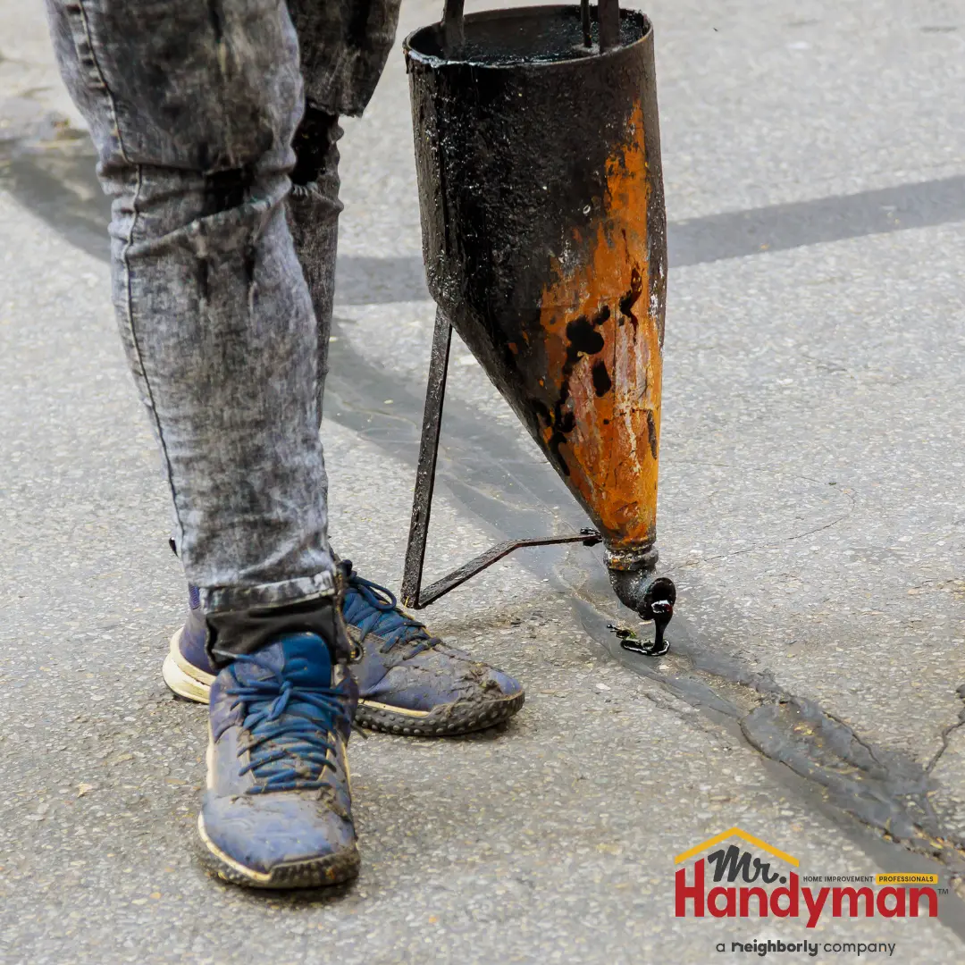 Mr. Handyman technician cleaning exterior surfaces and servicing entry doors at a commercial property in Greensburg, Pennsylvania