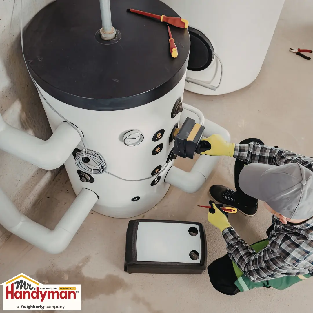 Handyman inspecting a residential water heater for repair or replacement in West Nashville Tennessee