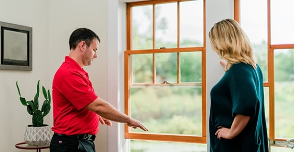 mr handyman service professional reviewing a window frame with a homeowner during a professional window assessment
