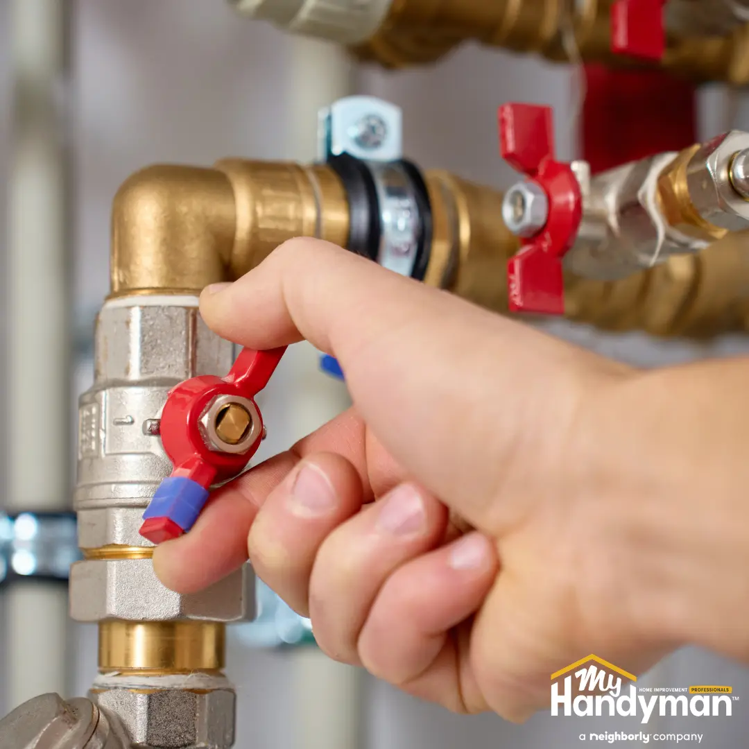 Handyman inspecting a pressure regulator valve on a home water supply line in Rock Hill South Carolina