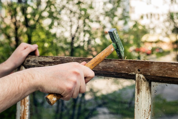 Homeowner inspecting wood rot.