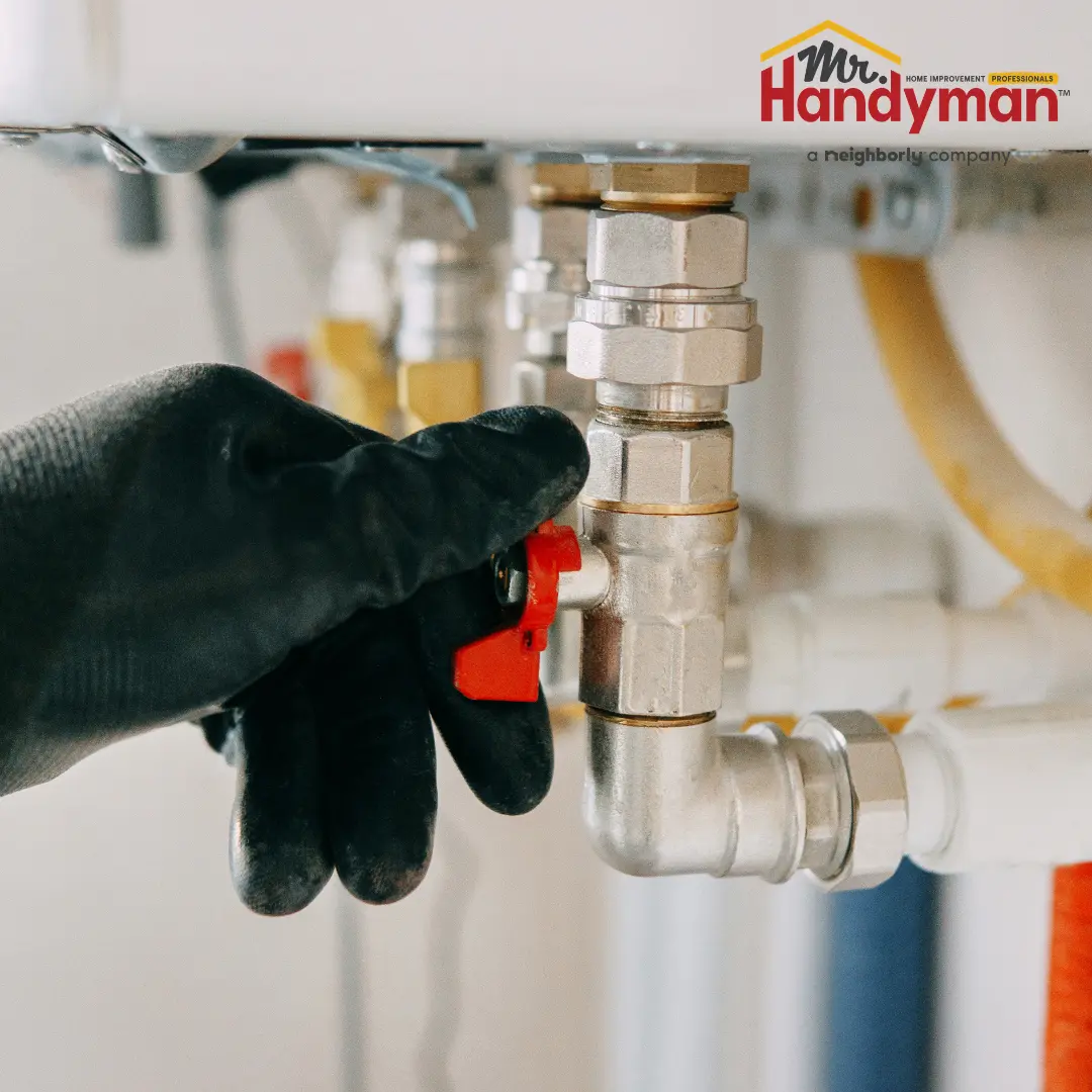 Mr. Handyman technician repairing a leaking faucet and inspecting supply lines