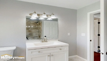Modern bathroom featuring a white vanity, mirror with overhead lighting.