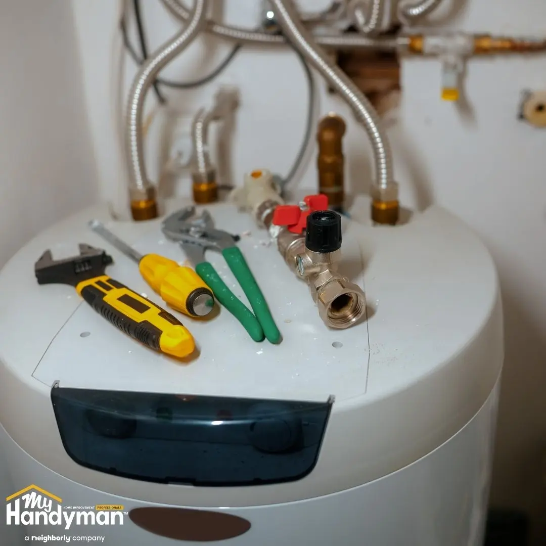 Close-up of a water heater top with various tools.