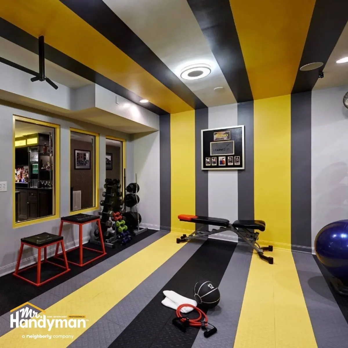 Home gym with striped yellow and gray walls.