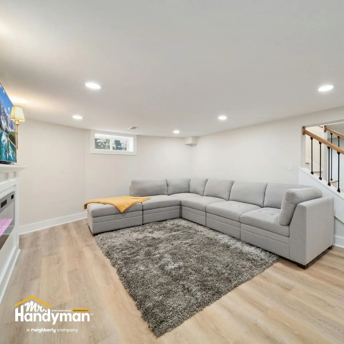 Cozy basement living room with a gray sectional sofa.