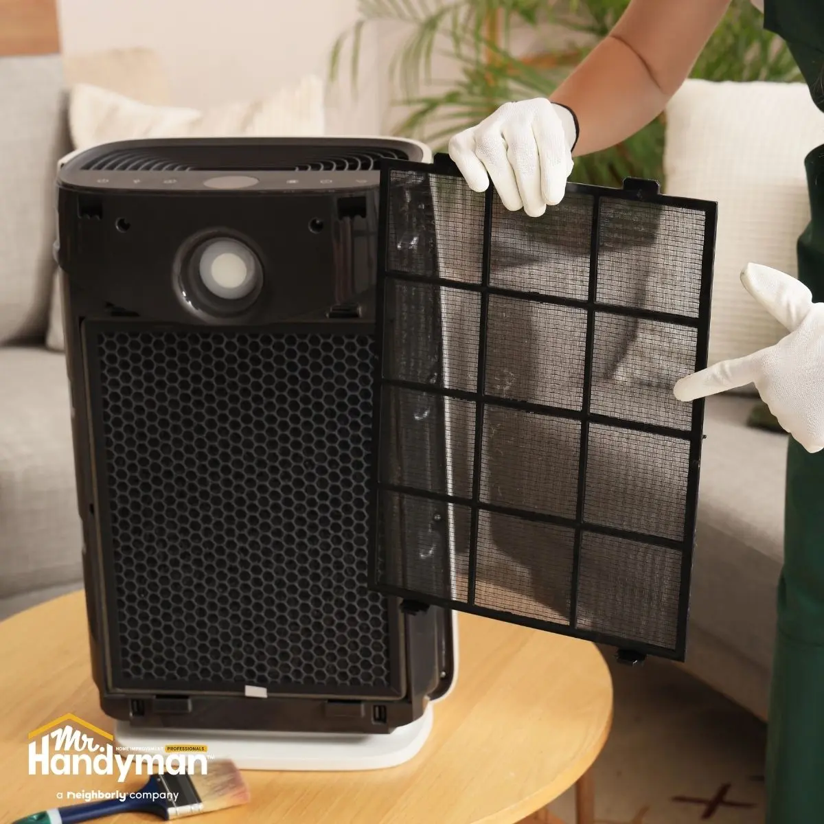 A person in gloves holding a removable air purifier filter.