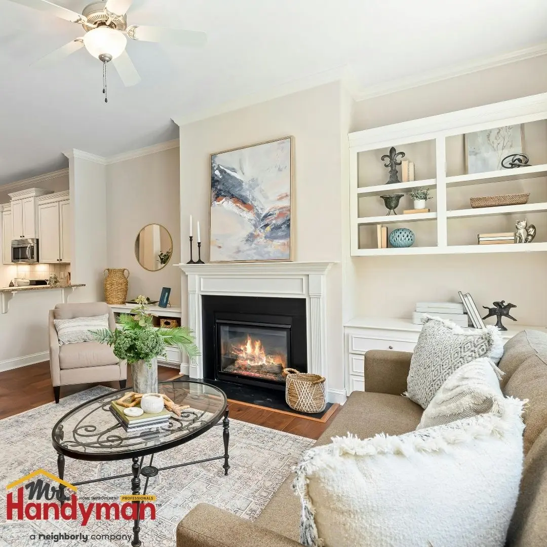 Bright, cozy living room with a fireplace, beige seating, glass coffee table, and built-in shelves.
