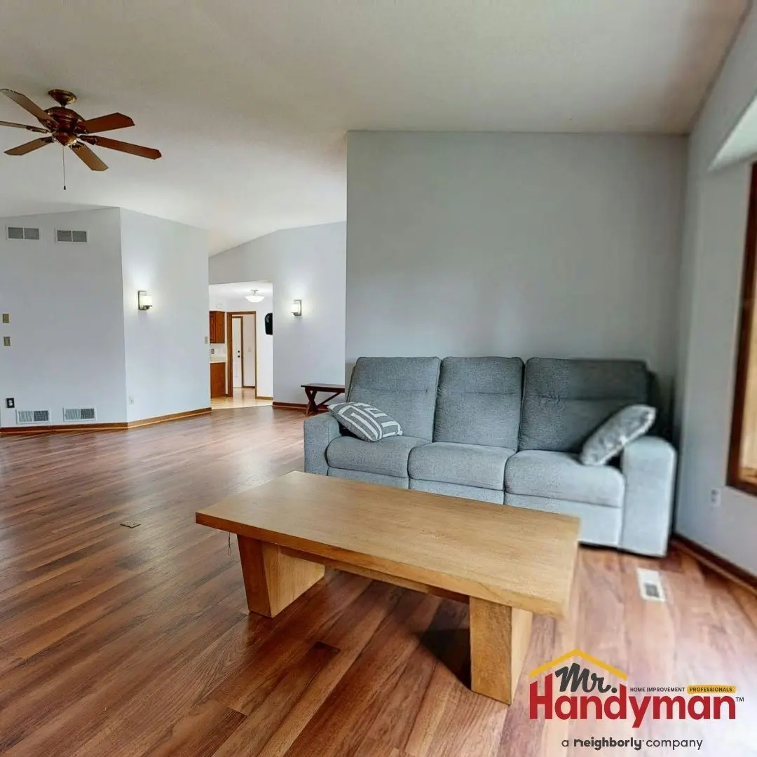 Living room with wooden floor and gray sofa.