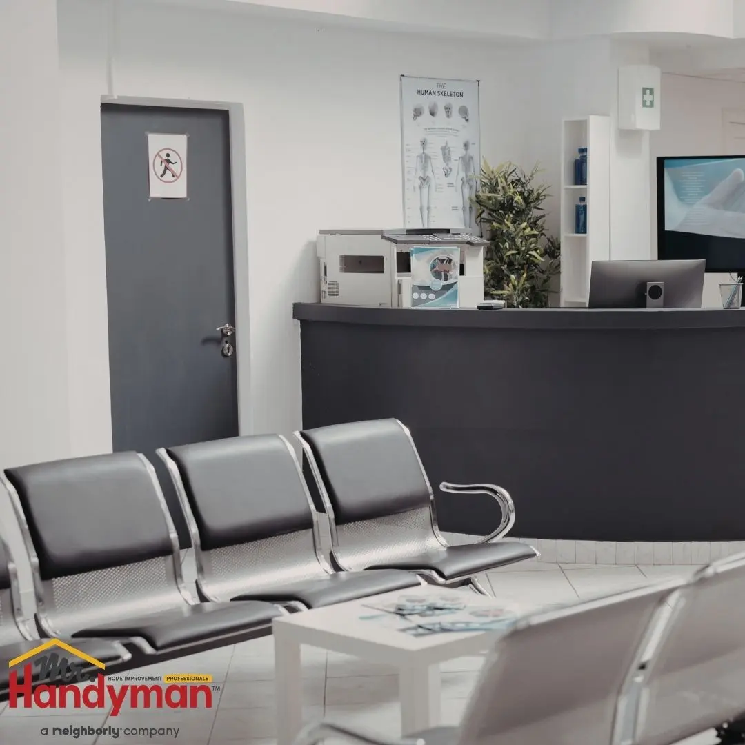 Mr. Handyman technician repairing and refreshing a commercial breakroom interior at a Plano, Texas business facility.