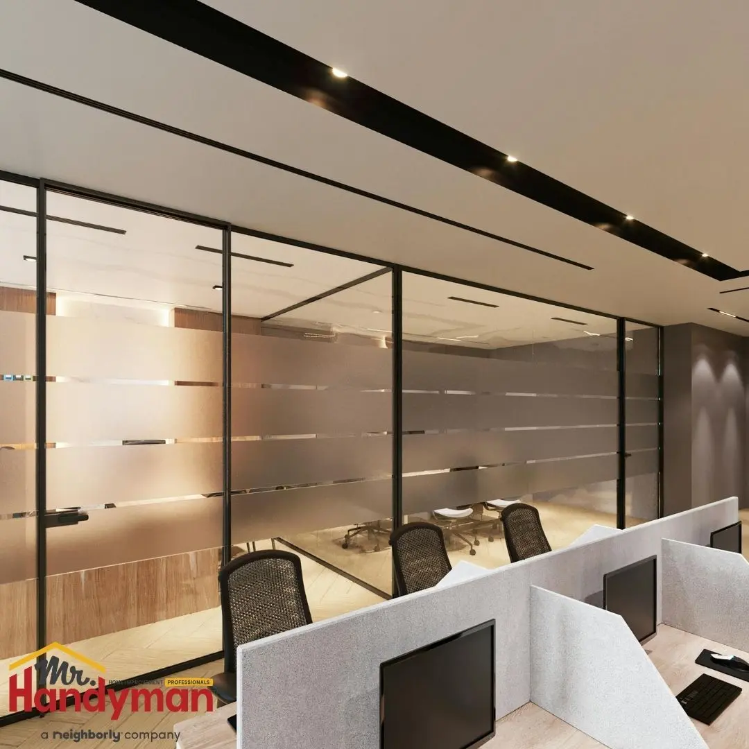 A modern office interior featuring frosted glass partitions, ergonomic chairs, and sleek desk setups.