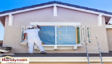 Painter painting the trim around a second-story window.