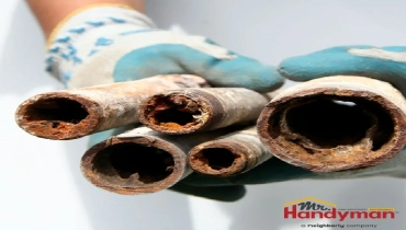 handyman inspecting a pressure regulator valve on a home water supply line in South Bend Indiana