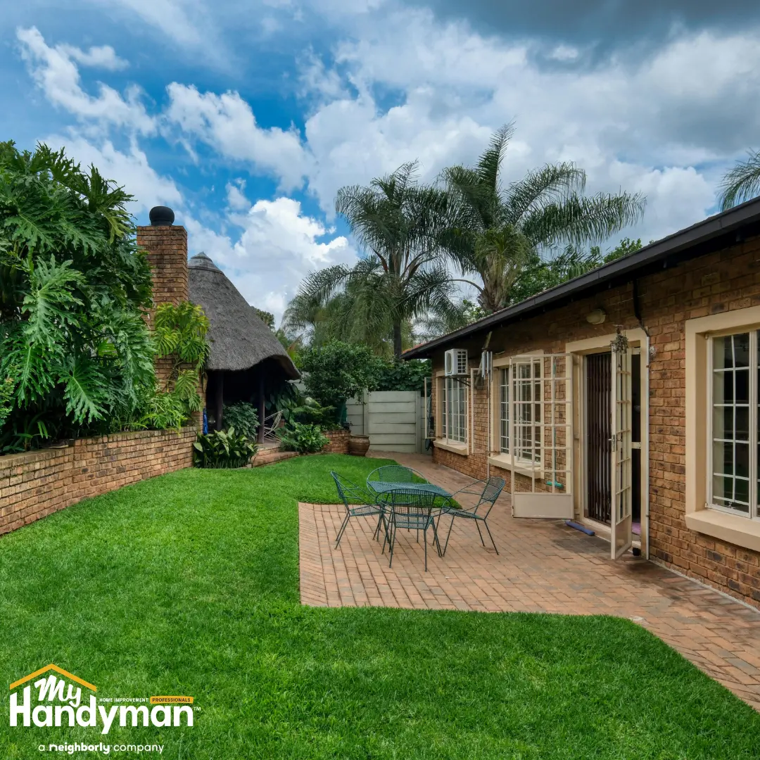 Beautiful outdoor space featuring a lush green lawn, patio area with seating.