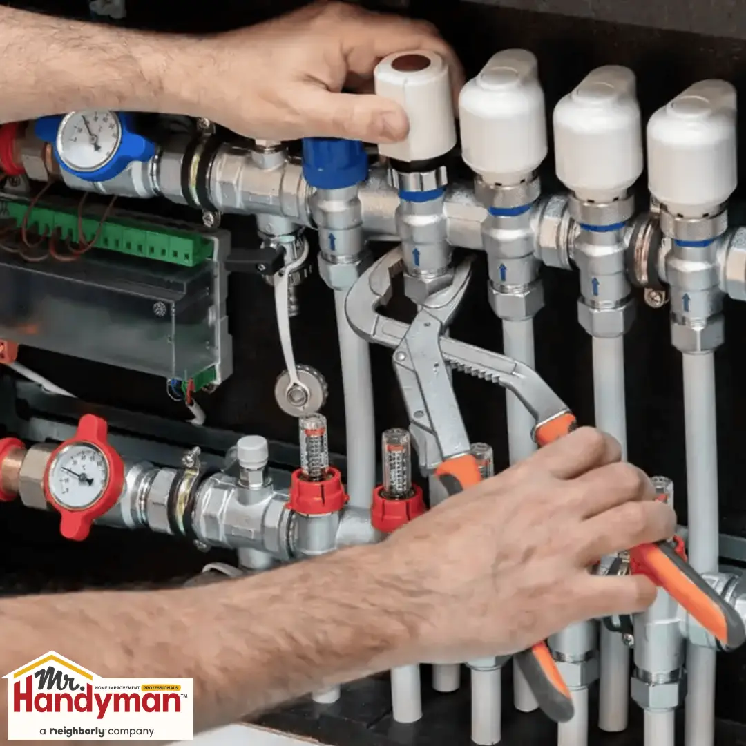 Person using pliers to adjust valves on a plumbing manifold system.